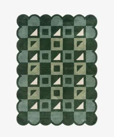 Top-down view of the Pine Patchwork rug against a white background, featuring a repeating geometric patchwork pattern of squares and triangles in shades of dark green, soft green, and cream, framed by a continuous dark green scalloped border.