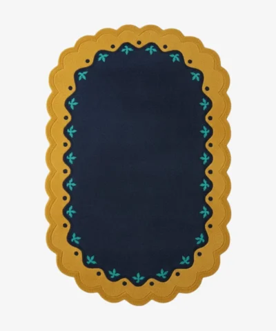 Top down view of the Royal Indigo rug featuring a deep navy blue center framed by a mustard gold scalloped border with delicate teal floral accents.