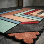 Close-up perspective of the Sage Echo rug, highlighting the plush hand-tufted wool texture and the vibrant contrast of the rust scalloped corner against the sage green and grey geometric blocks.