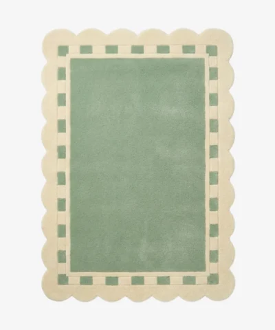 Top down view of the Sage Frame rug featuring a solid sage green center surrounded by a cream border with a decorative green square pattern and scalloped edges.