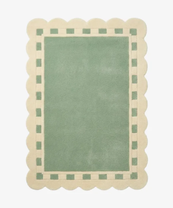 Top down view of the Sage Frame rug featuring a solid sage green center surrounded by a cream border with a decorative green square pattern and scalloped edges.