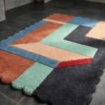 Perspective view of the Soft Switch rug highlighting the plush hand-tufted wool texture and the vibrant contrast of the rust and blue geometric sections.