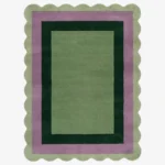 Top-down view of the Trimmed Forest rug against a white background, featuring a classic rectangular design with concentric color-block borders in light green, muted purple, and dark forest green, wrapped around a solid light green center and framed by a continuous light green scalloped edge.