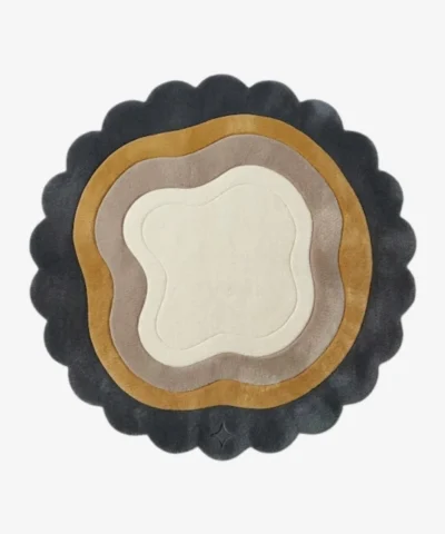 Top-down view of the circular Aurelith Flow rug, featuring a cream organic center surrounded by wavy concentric layers in soft taupe and mustard yellow, all framed by a thick, dark charcoal scalloped border.