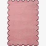 Top-down view of the rectangular Blush Halo rug, featuring a solid soft pink field with a continuous scalloped border and a thin black line outlining the wavy edge.