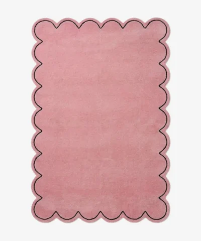 Top-down view of the rectangular Blush Halo rug, featuring a solid soft pink field with a continuous scalloped border and a thin black line outlining the wavy edge.