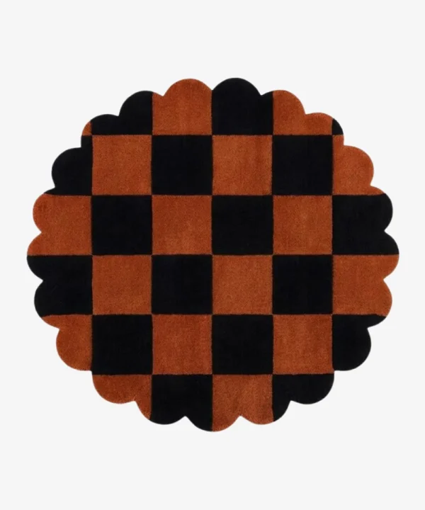 A top-down, flat lay view of the round Cinder Form rug against a grey background, showcasing its complete circular shape, abstract charcoal grey patterns over a cream field, and a continuous charcoal scalloped edge.