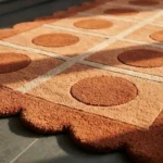 Close-up detail of the Cocoa Ridge runner rug bathed in sunlight, highlighting the thick, plush hand-tufted wool pile, the crisp carved definition of the cream grid lines, and the deep terracotta scalloped edge.