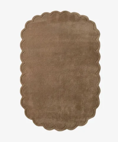 Top-down view of the rectangular Latte Halo rug, featuring a solid warm tan field and a continuous scalloped border accented by a delicate carved line detail.
