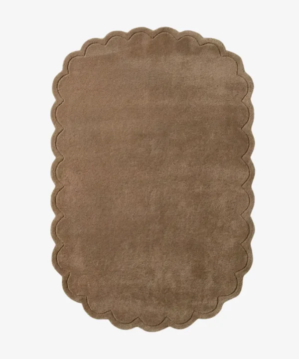 Top-down view of the rectangular Latte Halo rug, featuring a solid warm tan field and a continuous scalloped border accented by a delicate carved line detail.