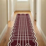 Long burgundy and cream Marvion Trace Runner Rug with a scalloped border laid out on a light wooden floor inside a bright hallway.