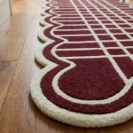 Angled close-up of the Marvion Trace Runner Rug highlighting the thick hand-tufted dense wool cut pile, cream geometric lines, and scalloped edge binding.