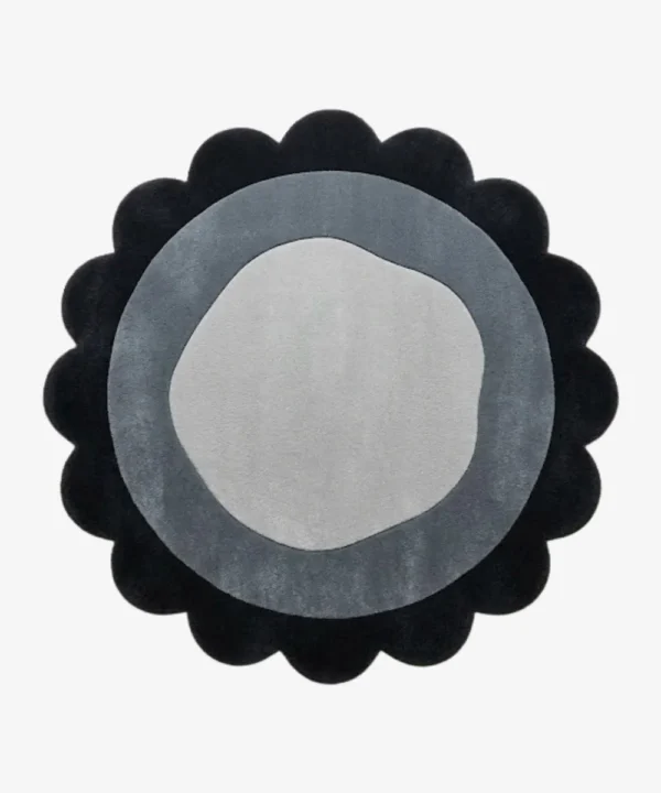 Top-down view of the circular Noctra Orb round rug, featuring a cream field with nested scalloped borders in soft black, gray, and a dark plum outer edge.