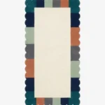 Top-down view of the Palette Parade runner rug featuring a clean ivory center field framed by a playful scalloped border with color-blocked segments in forest green, navy, mint, charcoal, and rust orange.