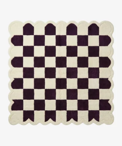 Top-down view of the square Porcelain Rhythm rug, featuring a classic checkerboard pattern in deep plum purple and cream, framed by a matching continuous cream scalloped border.