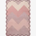 Top-down view of the Rose Chevron rug featuring a gradient zigzag pattern in shades of cream, soft blush, rose, and mauve, framed by a continuous scalloped border with a thin black outline.