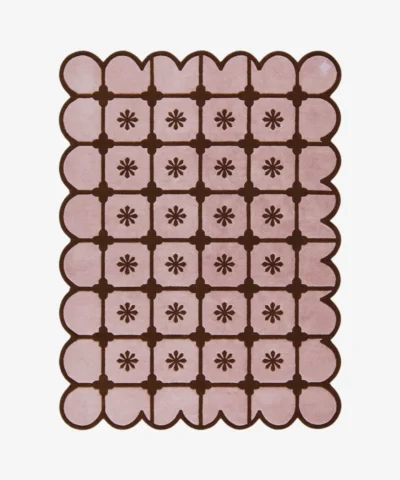 Top-down view of the rectangular Roselle Lattice rug, featuring a soft pink base with a dark brown grid pattern, a central floral motif in each square, and a matching continuous brown scalloped border.