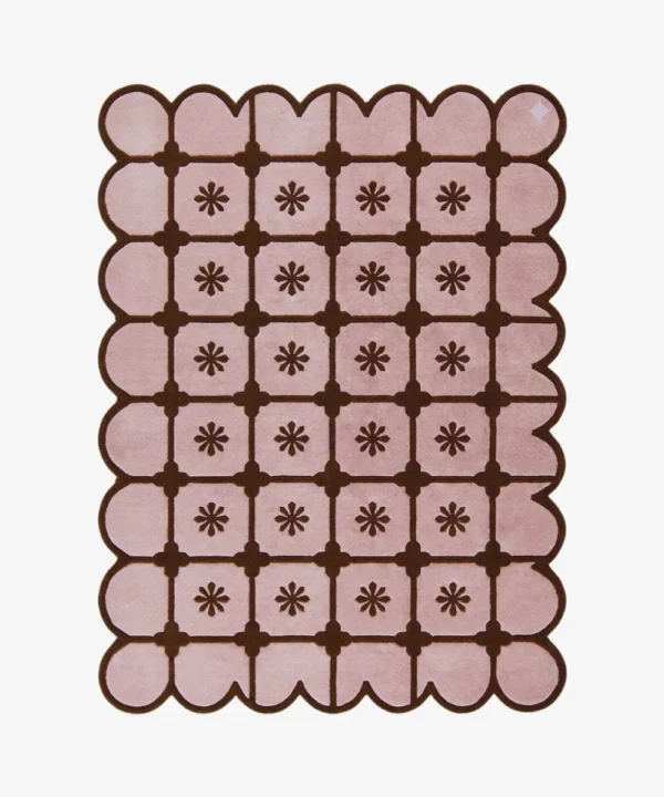 Top-down view of the rectangular Roselle Lattice rug, featuring a soft pink base with a dark brown grid pattern, a central floral motif in each square, and a matching continuous brown scalloped border.