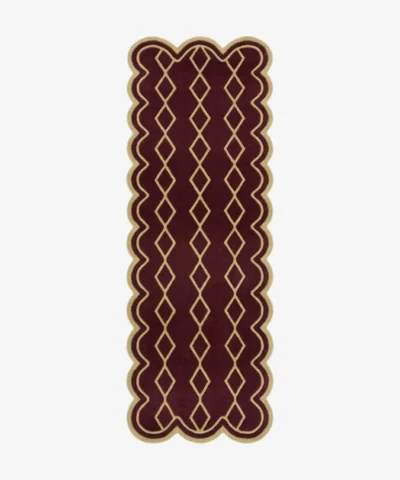 Top down view of the hand-tufted Solyvr Axis Runner Rug featuring a rich burgundy background, a gold geometric diamond pattern, and scalloped edges.