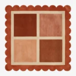 Top-down view of the square Sunset Panel rug featuring a cream grid with four color-blocked squares in shades of rust and peach, framed by a thick rust orange scalloped border.