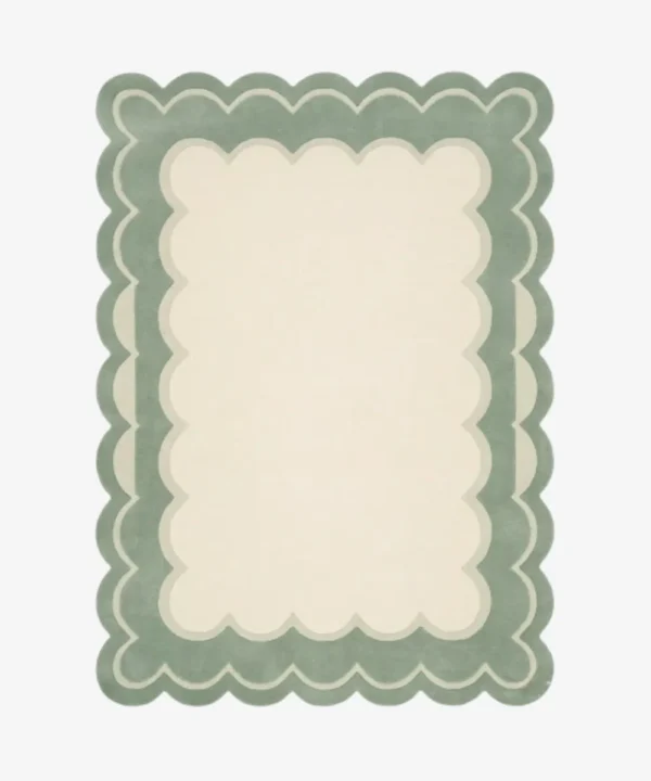 Top-down view of the rectangular Sylvena Crest rug, featuring a large solid cream center framed by a delicate inner wavy contour line and a thick, soft sage green scalloped outer border.