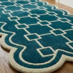 Angled close-up of the Terenza Coil Runner Rug highlighting the thick cut-pile wool construction, raised cream geometric lines, and dense scalloped border binding.