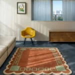 Perspective view of the Terrain Frame scalloped rug styled in a modern, sunlit living room, contrasting beautifully against a dark blue floor alongside a bright yellow mid-century accent chair and a cream sofa.