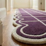 Close-up angled detail of the Velquor Vane runner rug, highlighting the dense hand-tufted wool pile, the neatly carved cream grid lines, and the thick, plush undulating scalloped edge resting on a wooden floor.