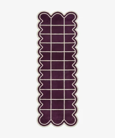 Top-down view of the Velquor Vane runner rug, featuring a rich plum purple background with a crisp cream geometric grid pattern, framed by a deeply contoured wavy cream border.