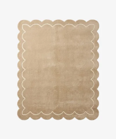 Top-down view of the rectangular Velune Nest rug, featuring a solid warm tan background bordered by a scalloped edge and a delicate, continuous cream inner line mimicking the wavy silhouette.