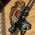 Angled close-up detail of the Alligator Skeleton rug's midsection, showcasing the plush thickness of the black wool background and the deeply carved white ribcage and spine.