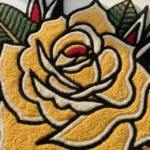 Close-up macro detail of the Classic Inked Rose rug, highlighting the totally dense hand-tufted texture and the deep carving of the vibrant red rose petals.