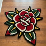 Perspective view of the die-cut Classic Rose Tattoo Rug styled on a dark hardwood floor in a cozy den next to a brown leather armchair and a lit stone fireplace.