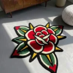 High-angle perspective view of the die-cut Classic Rose Tattoo Rug, resting on a dark wood floor in a cozy room, next to a brown leather wingback chair.