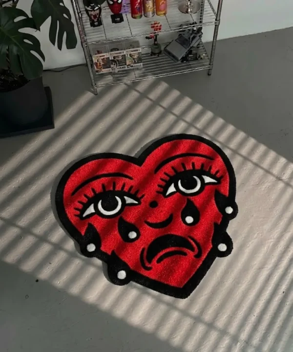 Perspective view of the Crying Heart traditional tattoo rug styled on a dark slate tile floor in a sunlit modern entryway, positioned next to a dark wood console table.
