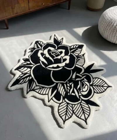 Perspective view of the Dual Rose black and white traditional tattoo rug resting on a smooth concrete floor, beautifully bathed in natural sunlight and shadows.