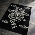 Angled view of the black and white Inferno Dragon Tattoo Rug, showcasing its rectangular shape and the striking contrast of the white dragon motif.