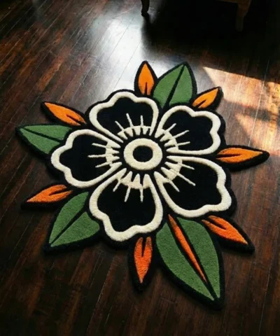 Flat top-down view of the Inked Garden Rug, clearly displaying the entire repeating traditional American tattoo flash pattern of red roses, blue accents, green leaves, and black dotted stars on a cream center, framed by a distinctive dark scalloped border with red trim.