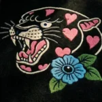 Top-down flat view of the Inkheart Panther rug, clearly displaying the bold traditional tattoo design of a roaring panther, a vibrant blue flower, and the repeating border of pink hearts.