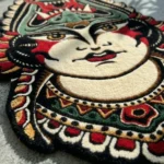 Extreme low-angle close-up of the Lady Face rug, emphasizing the thick plush texture of the 100% New Zealand wool pile and the deep carving along the decorative collar and chin.