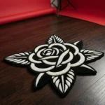 Angled view of the Noir Rose black and white flower rug placed on a dark wood floor in a photography studio setting, featuring a vibrant red seamless paper backdrop unrolled in the background.