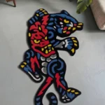 High-angle perspective view of the hand-tufted Phantom Panther rug resting on a smooth grey concrete floor, positioned next to a modern wooden cabinet and a large green houseplant in a sunlit space.