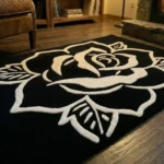Perspective view of the Phantom Rose black and white rug styled in a modern entryway with dark slate tile flooring, wood paneling, and a minimalist black console table, bathed in a beam of natural sunlight.