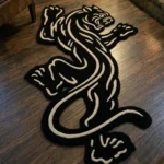 Perspective view of the Black Veil tattoo flash rose rug styled in a modern studio space on a grey concrete floor, positioned near a potted plant and a metal shelving unit displaying pop culture collectibles.