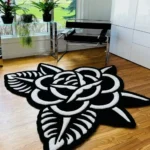 Perspective view of the Thornveil tattoo flash rose rug placed on a light oak wooden floor in a bright, modern room featuring large windows, potted plants, a glass table, and a sleek black modern chair.