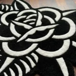 Close-up detail of the Thornveil rug, highlighting the dense hand-tufted wool pile and the deep 3D carving that separates the stark white rose petals and leaves from the solid black background.