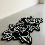 Perspective view of the elongated black and white Twin Ink Rose rug placed on a smooth, light concrete floor in a bright, minimalist modern space bathed in natural light.