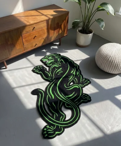 Black and green Neon Panther Rug styled in a sunlit room on a grey floor, positioned next to a mid-century modern wooden cabinet and a white pouf.