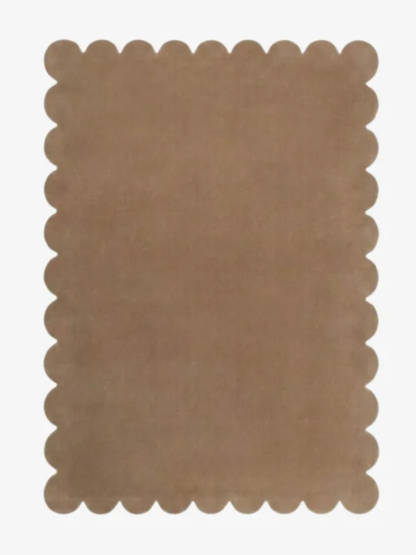 Top down view of the Amber Glint tan colored hand tufted wool rug on a white background showing the rectangular shape and scalloped edges.
