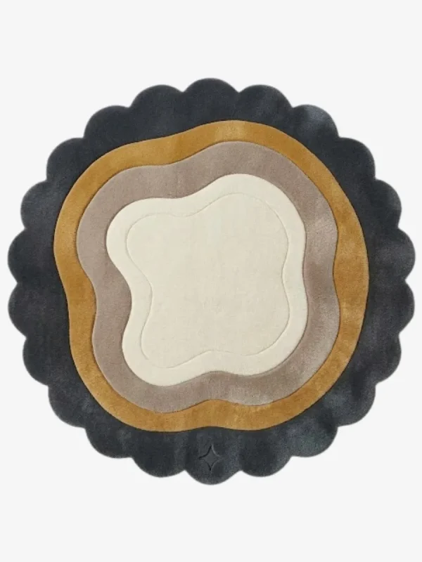 Top-down view of the circular Aurelith Flow rug, featuring a cream organic center surrounded by wavy concentric layers in soft taupe and mustard yellow, all framed by a thick, dark charcoal scalloped border.